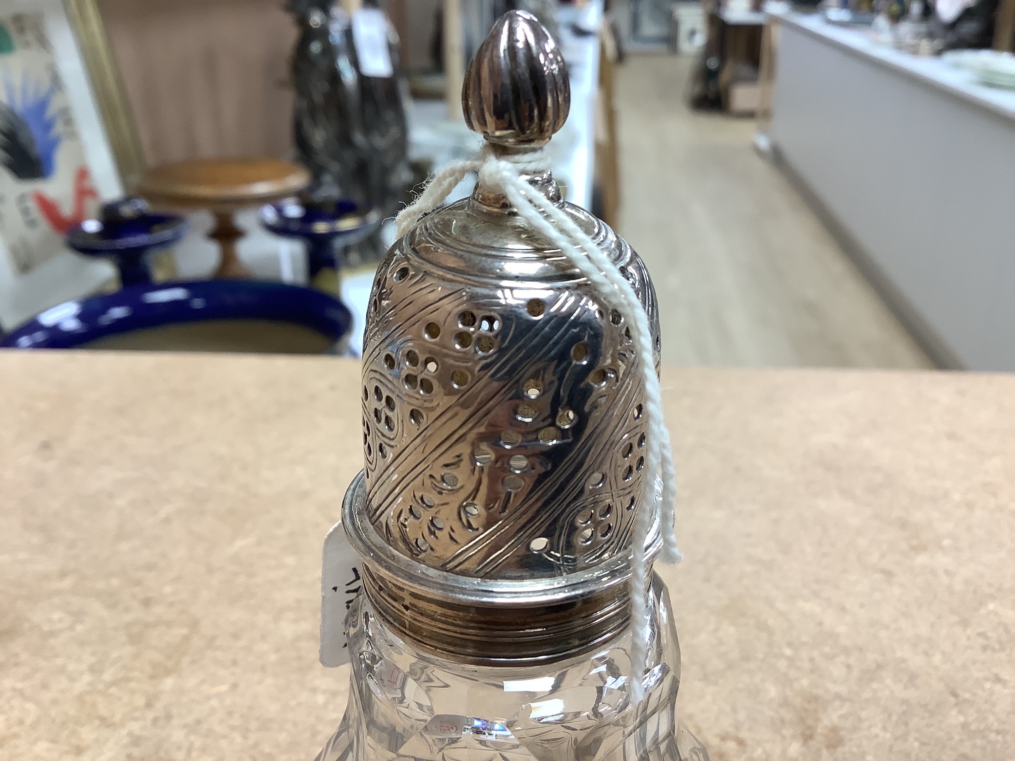 A late Victorian silver topped cut glass scent bottle, London, 1890, 15cm, a later silver mounted glass condiment ewer and silver mounted glass caster.